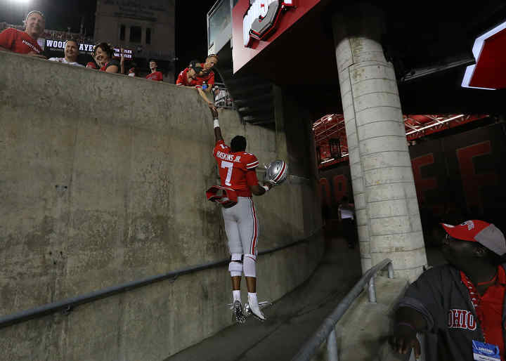 Ohio State quarterback Dwayne Haskins Jr. jumps to touch hands with a fan following the Buckeyes  game against Indiana at Ohio Stadium in Columbus.   (Jonathan Quilter / The Columbus Dispatch)